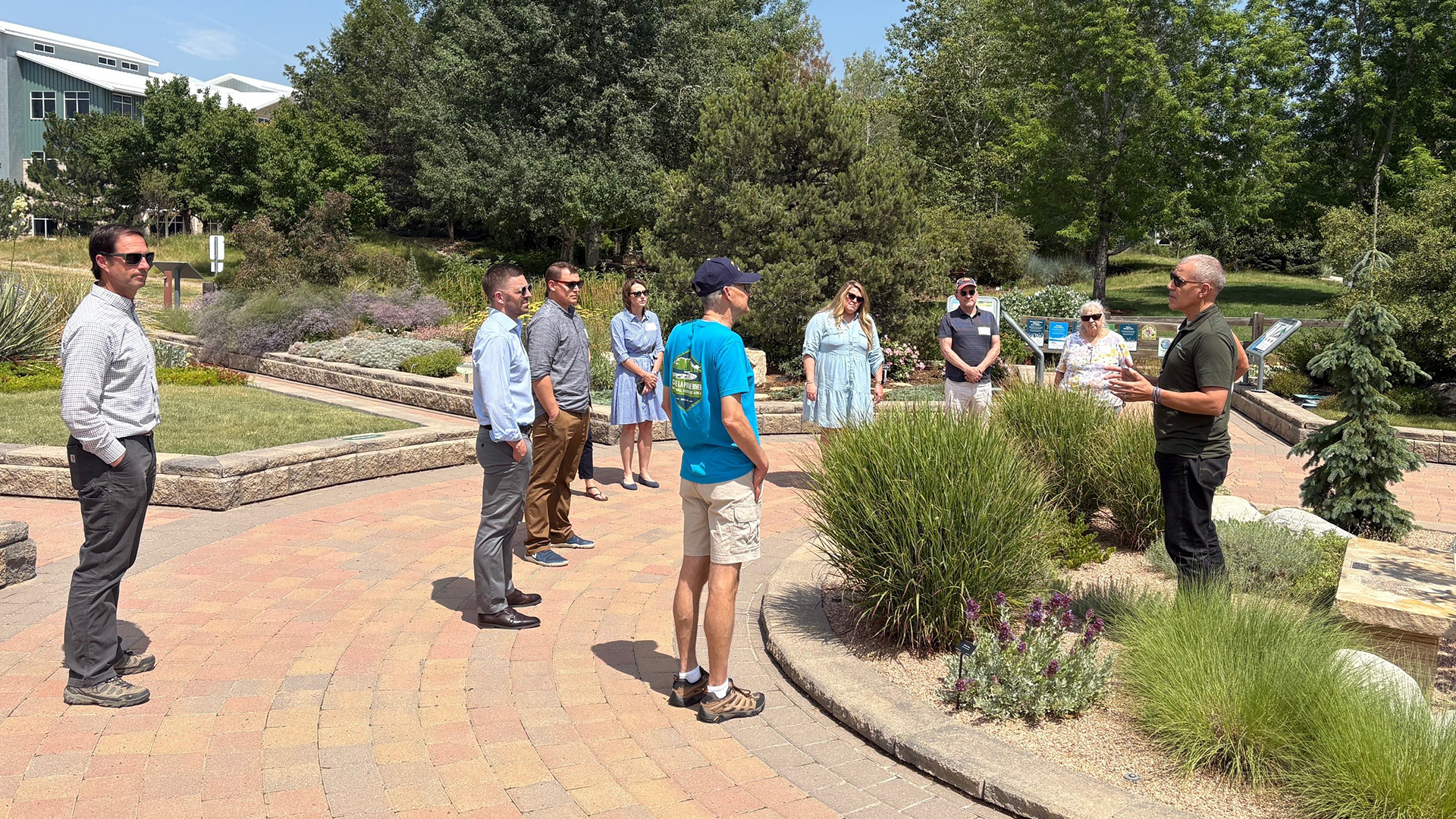 Employee conducting a tour of the Conservation Gardens for several people standing around him. 