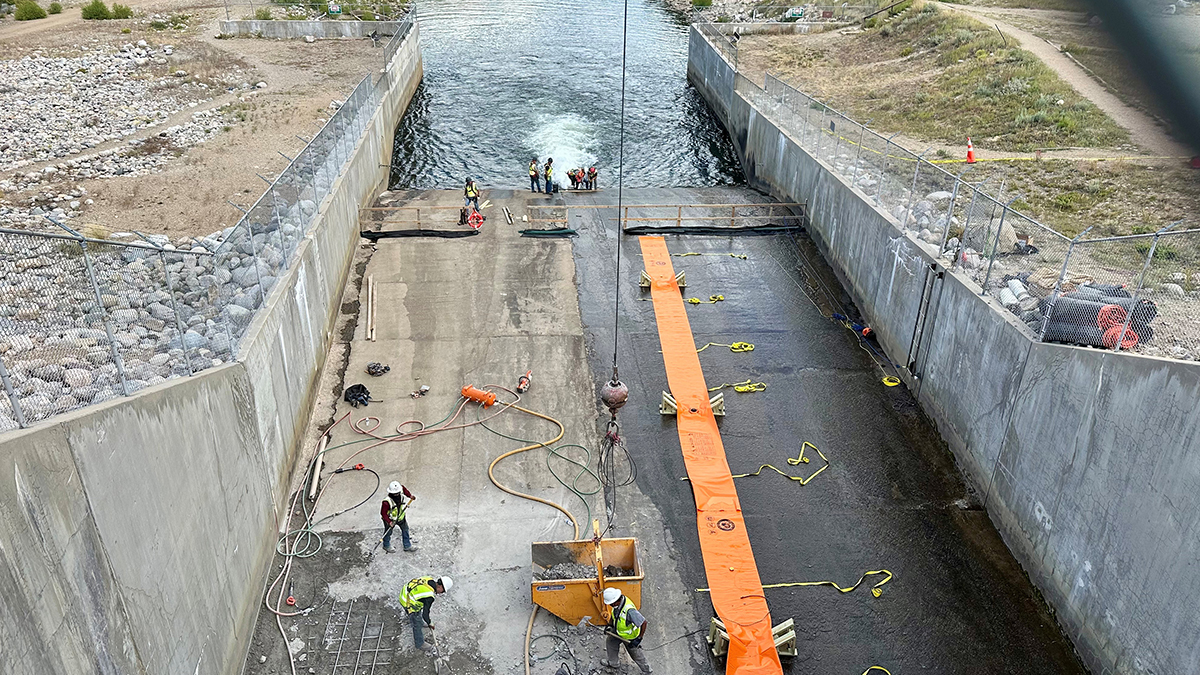 Men working on the concrete spillway below Shadow Mountain Reservoir. 