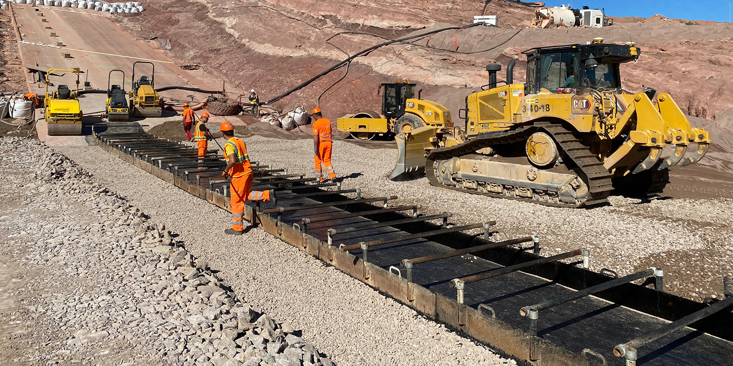 Crews place forms on the asphalt core of the main dam to hand-place a lift of the aslphat core.