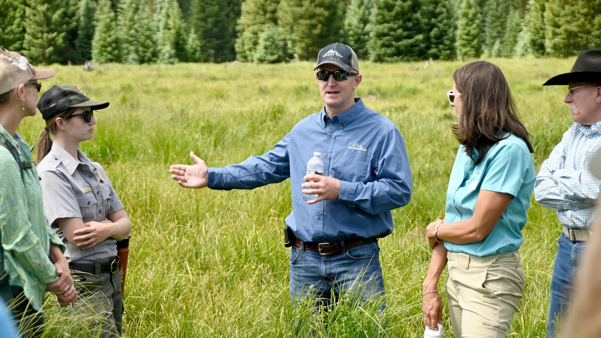 People standing in a field talking about partnerships.
