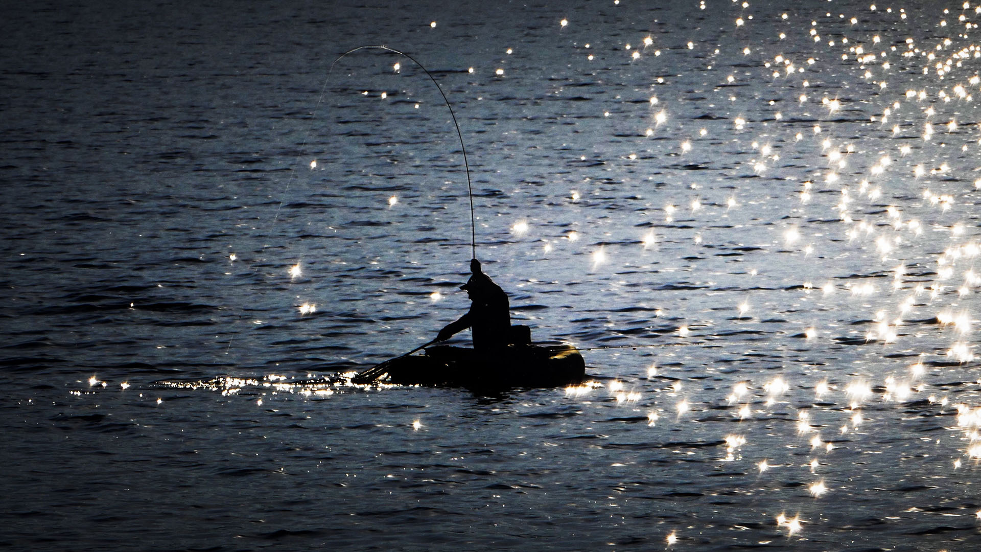 Fisherman fishing in middle of lake.