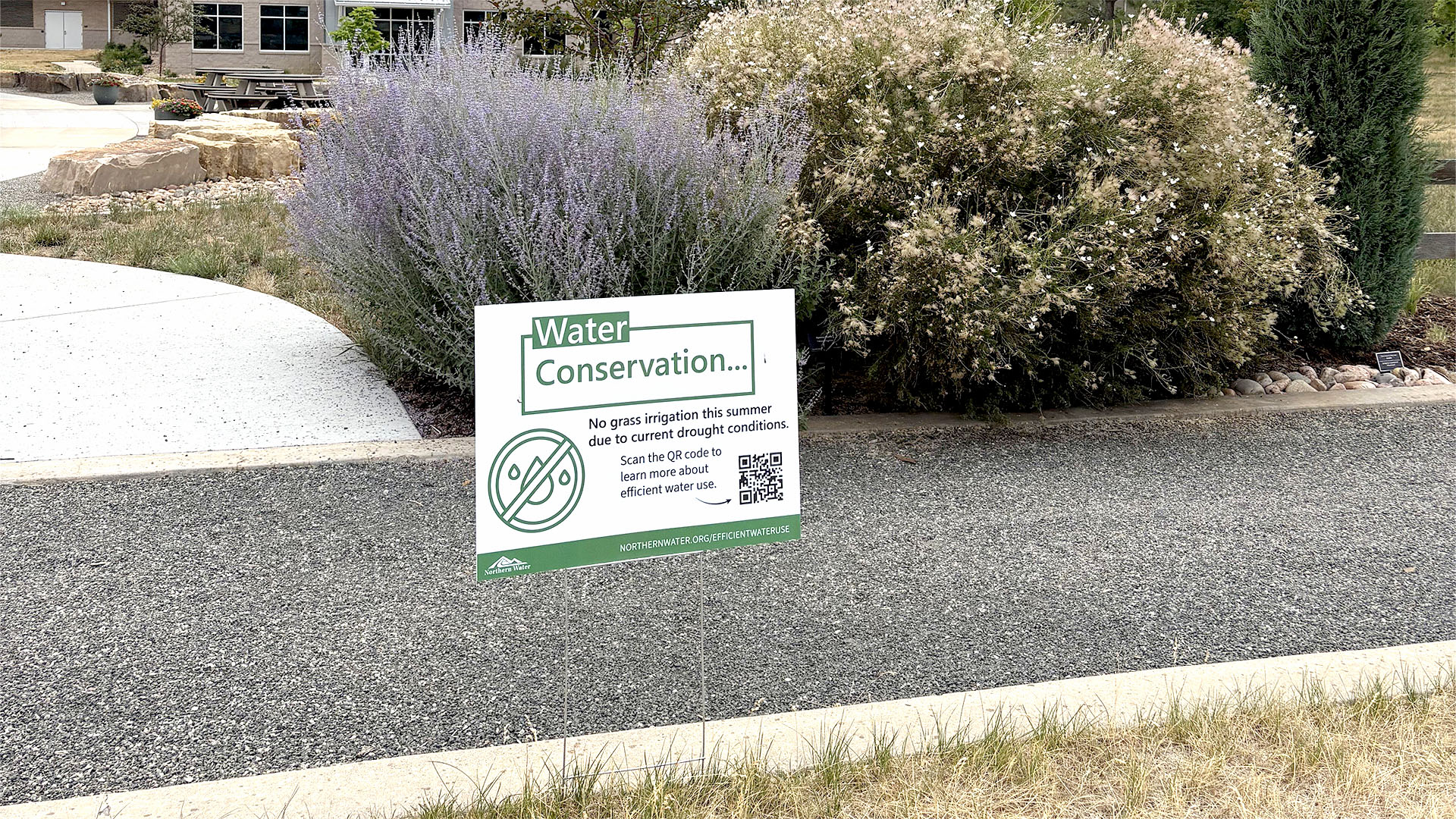 Water Conservation Sign on the edge of dry grass.
