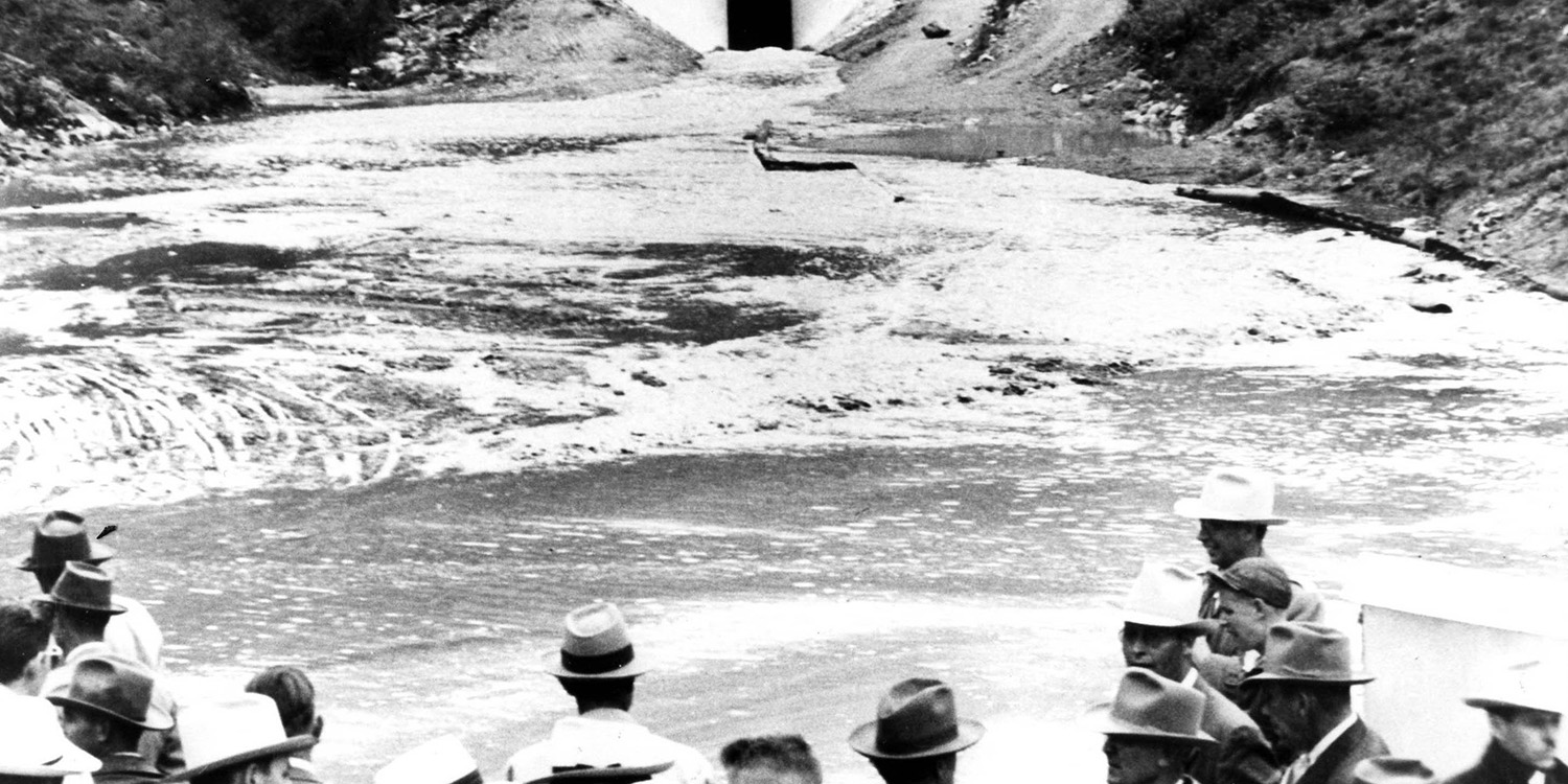 Black and white photo of the first water exiting the East Portal of the Adams Tunnel