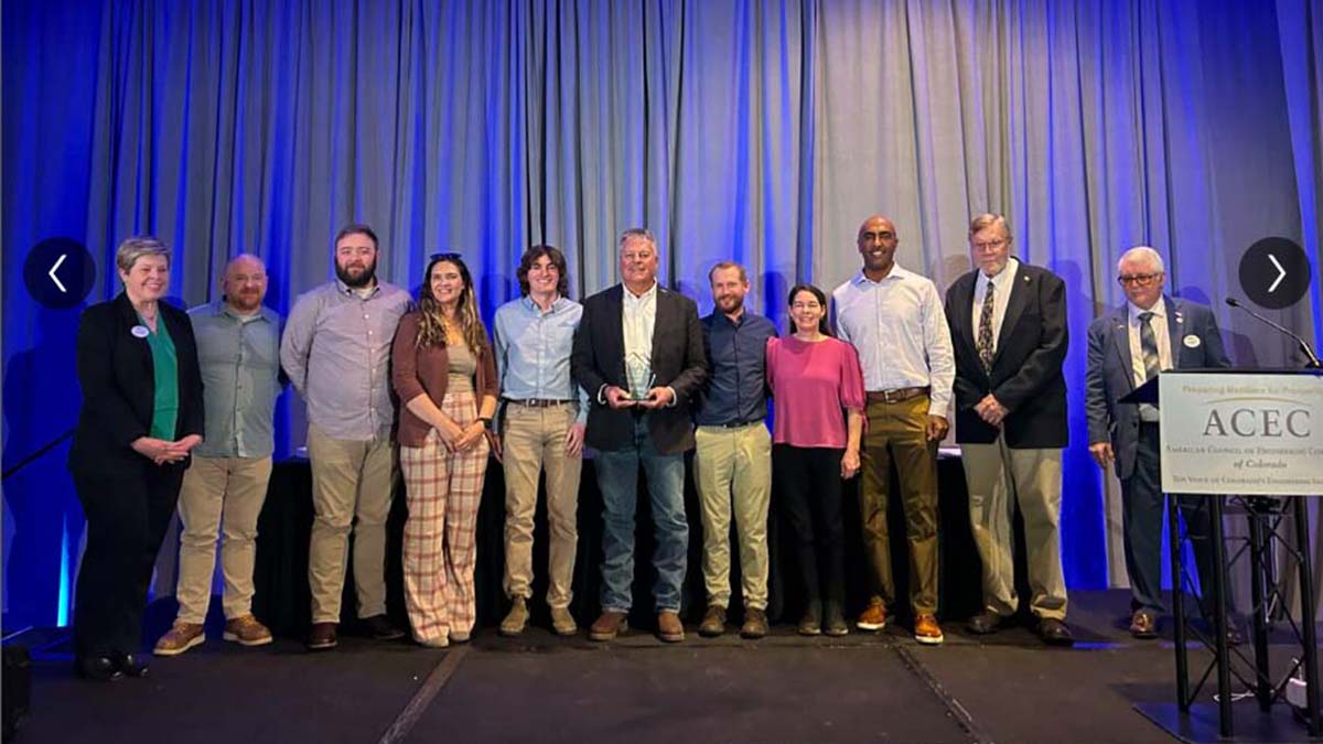 Group of people standing on a stage receiving an award from ACEC