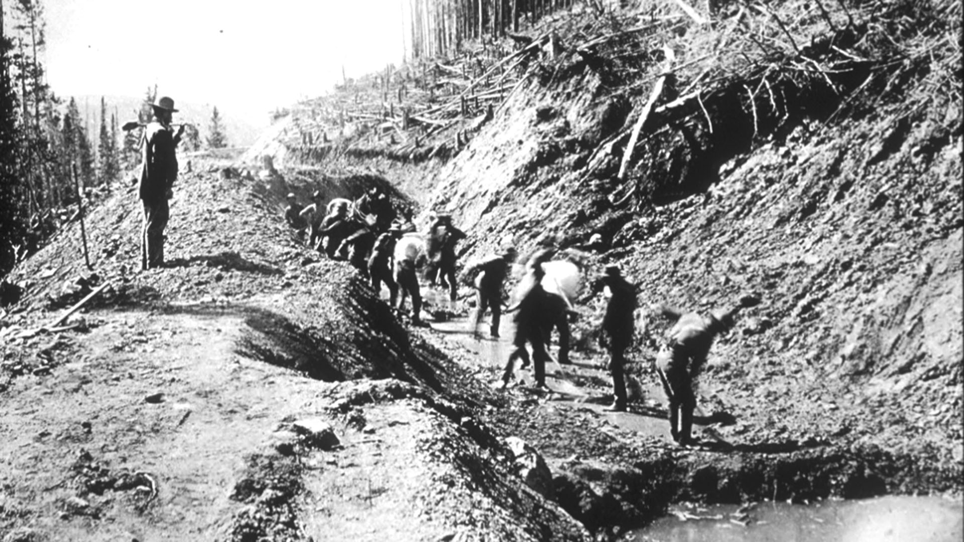 Historic image of men standing in the bottom of Grand River which eventually was renamed the Colorado River. 