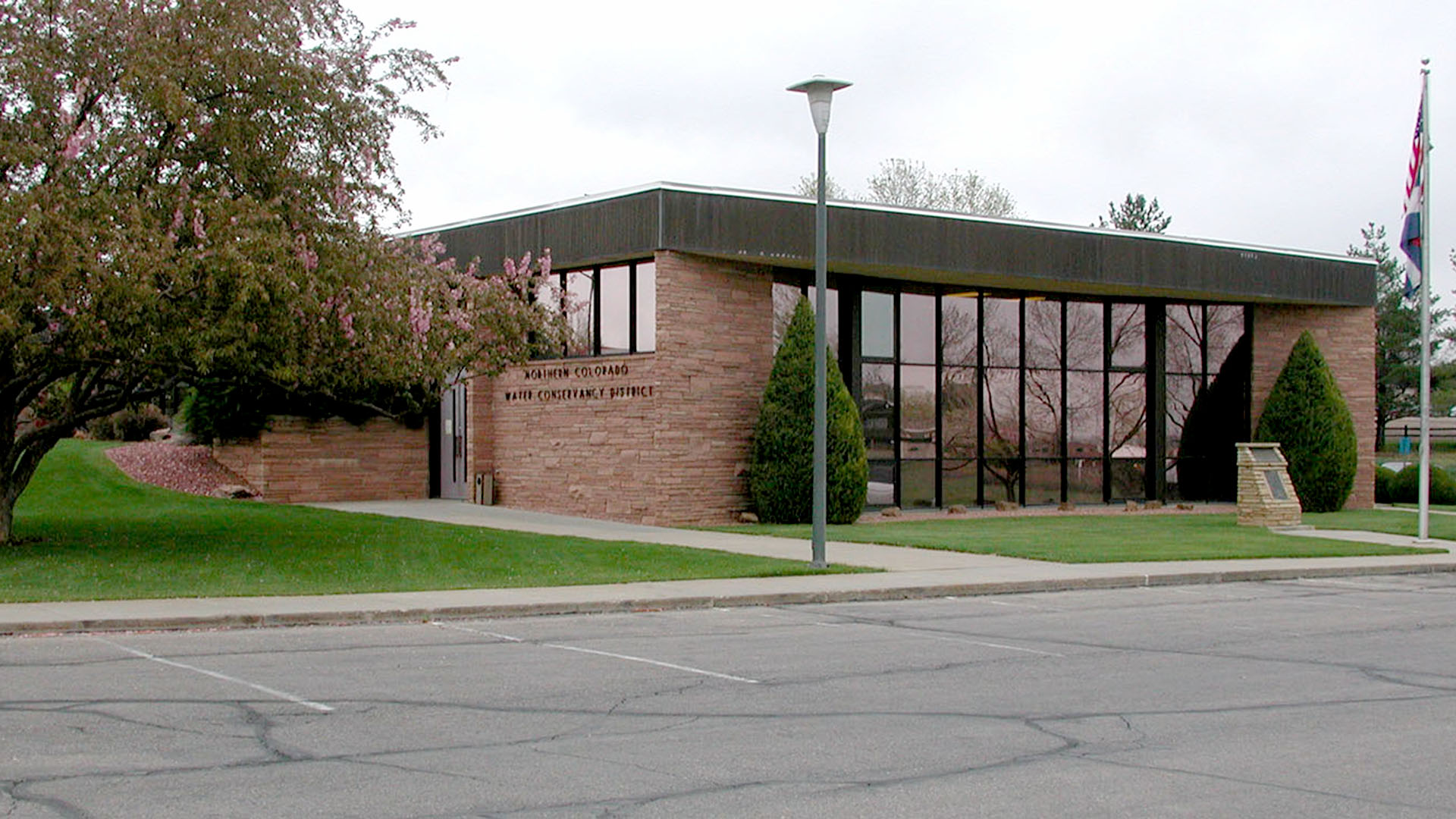 A building with glass windows on the front and stacked stone. 
