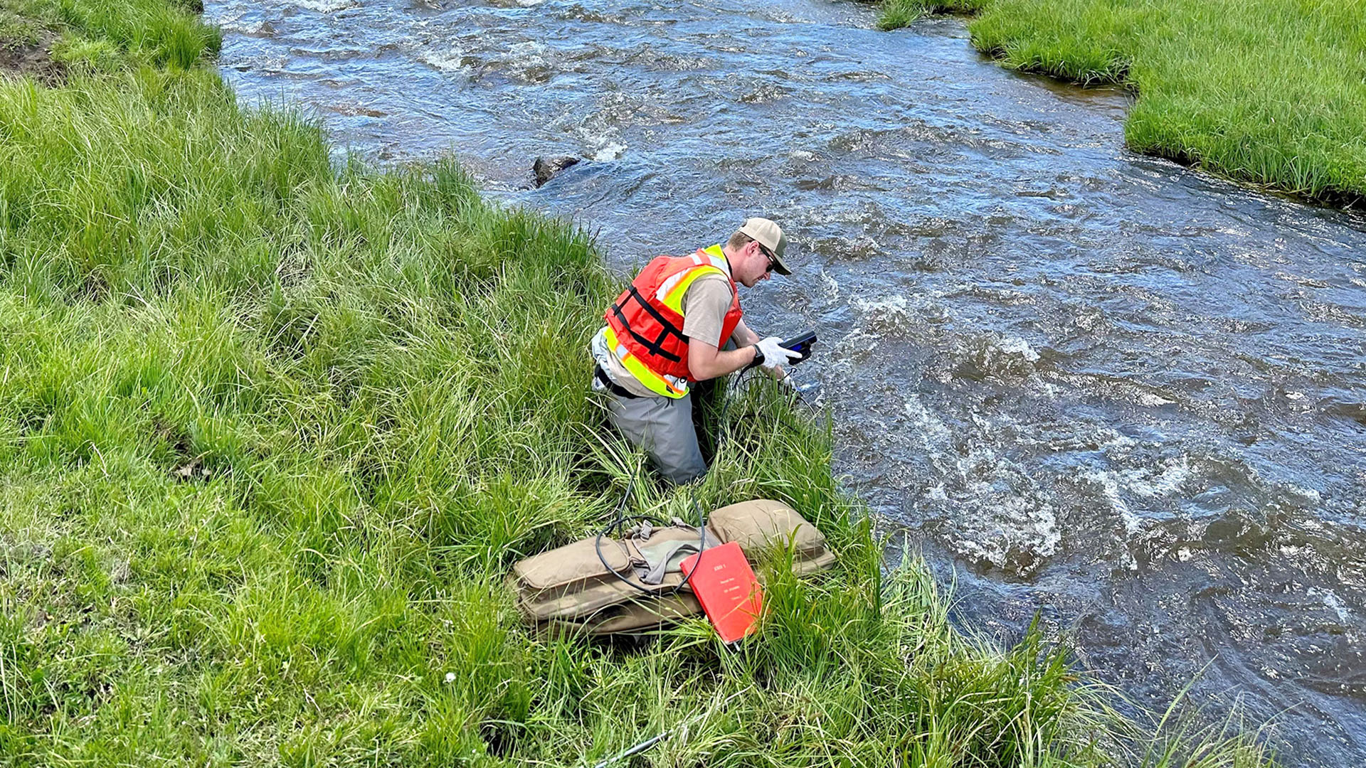 Man next to river testing water quality.