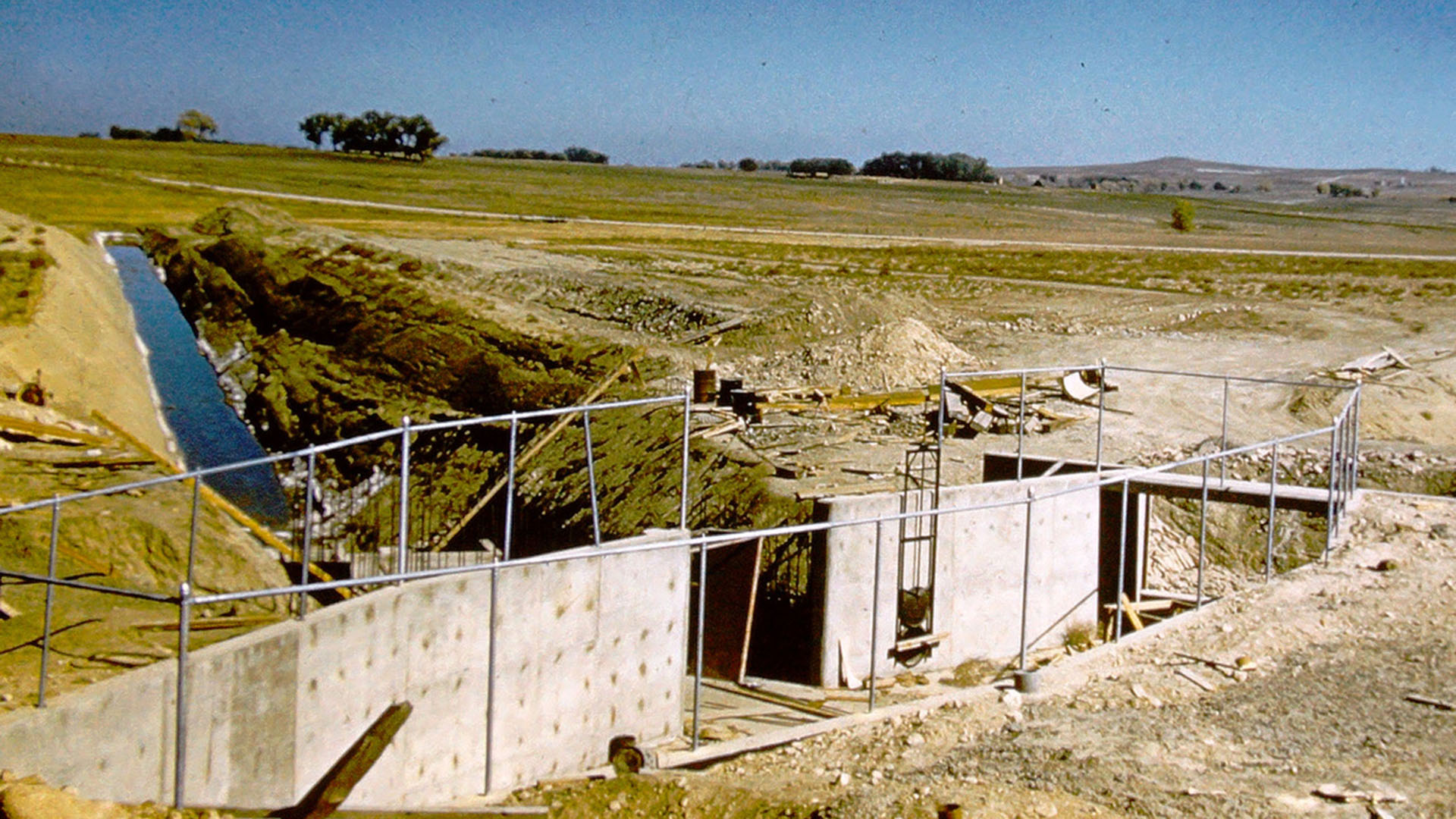 Water coming down a ditch with a headgate at end.