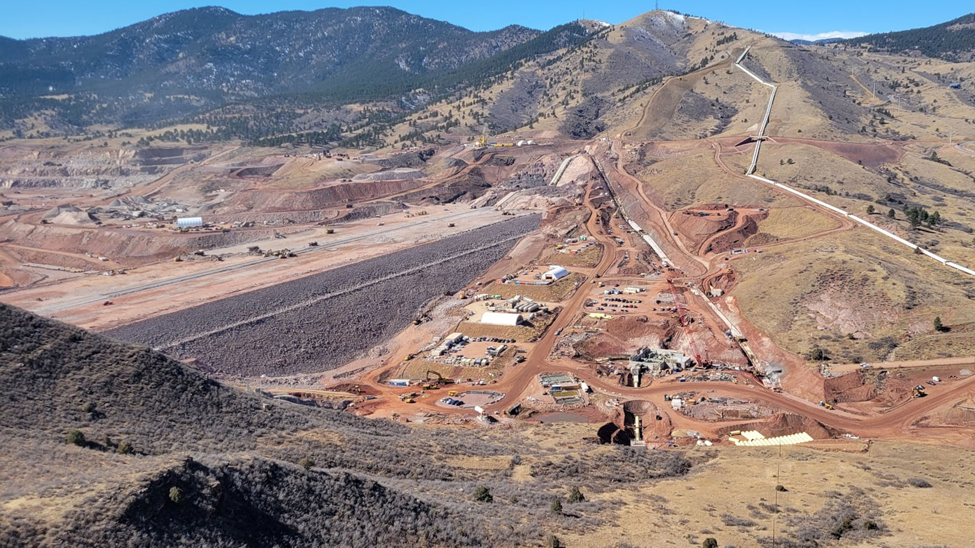 Building a dam about half way done. Equipment and construction below the dam. 