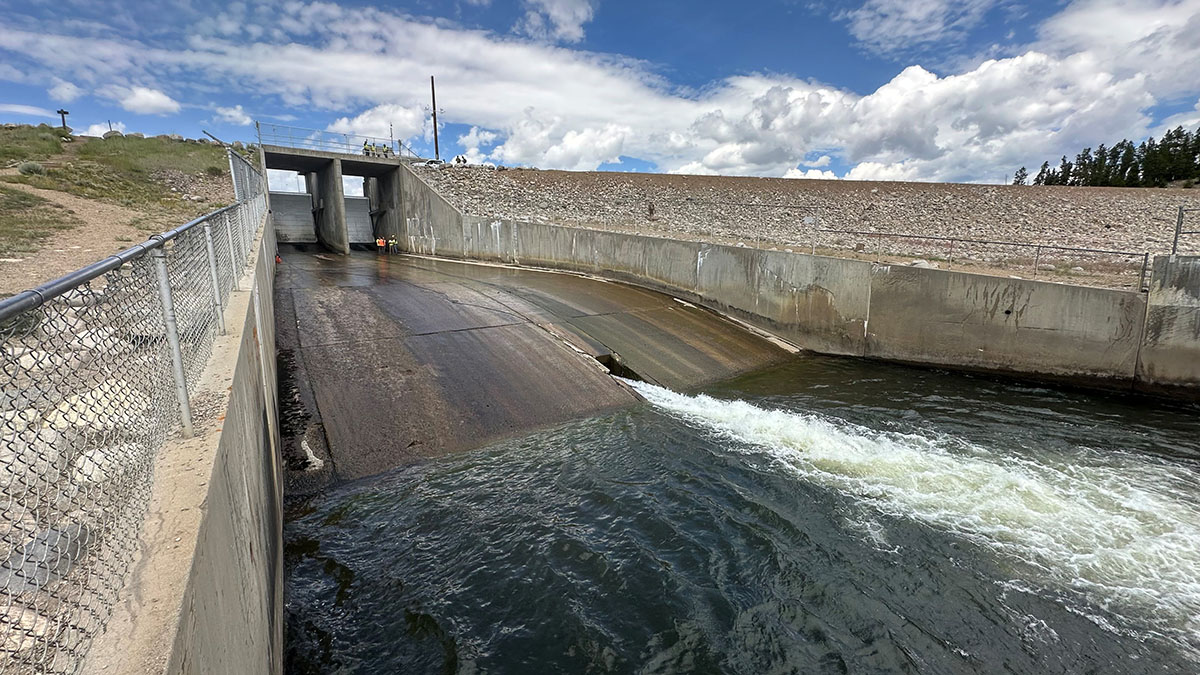 People standing on the spillway of Shadow Mountain Dam doing a site visit before work. 