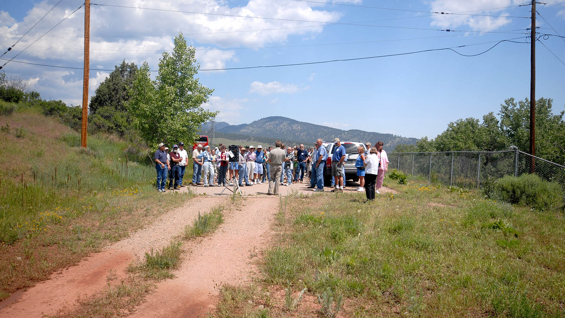 People standing listening to a person talk about a potential reservoir site.