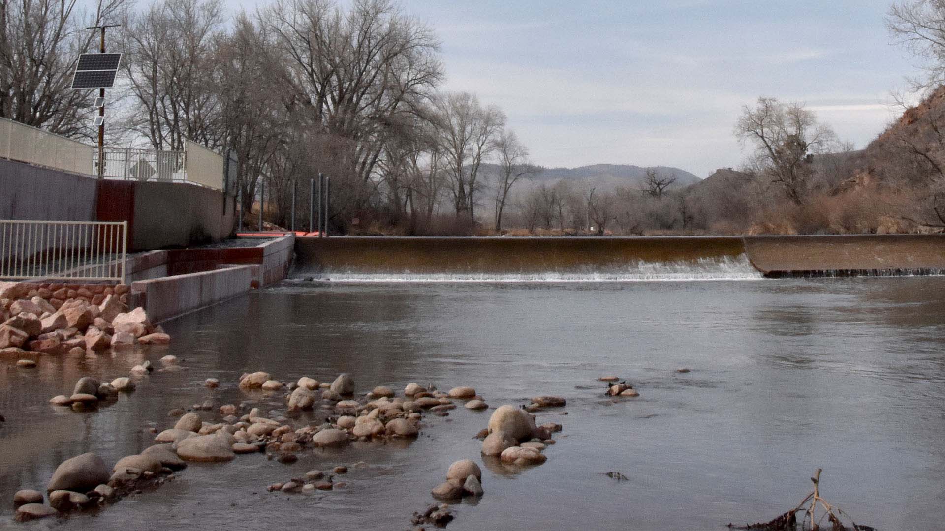 Water rolling over an embankment within a river.
