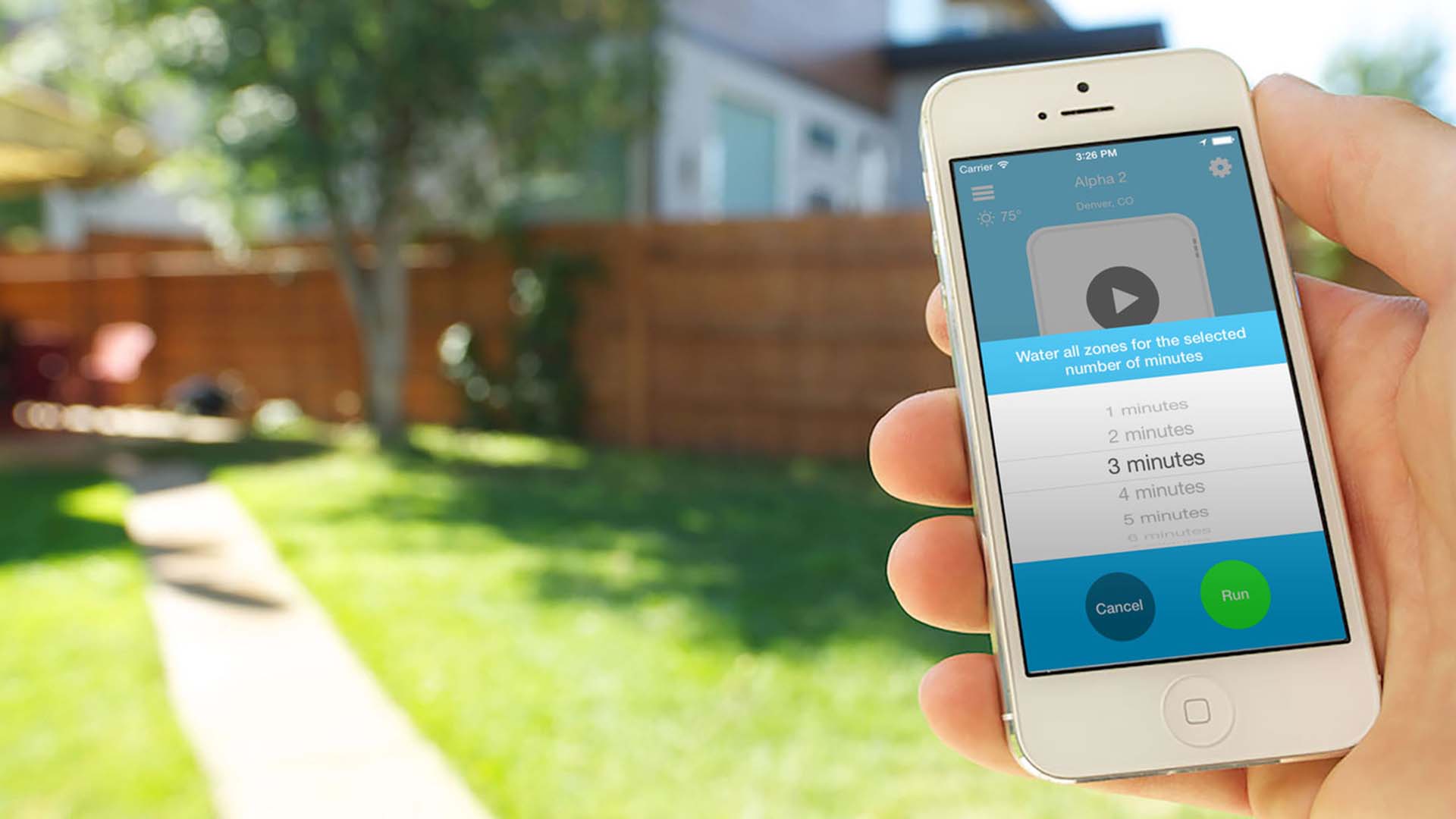 Hand holding a mobile photo displacing an irrigation smart controller app.