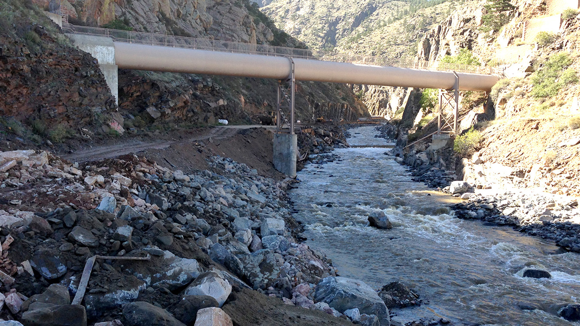 With a water siphon over the road, debris from the flood broke up the road.
