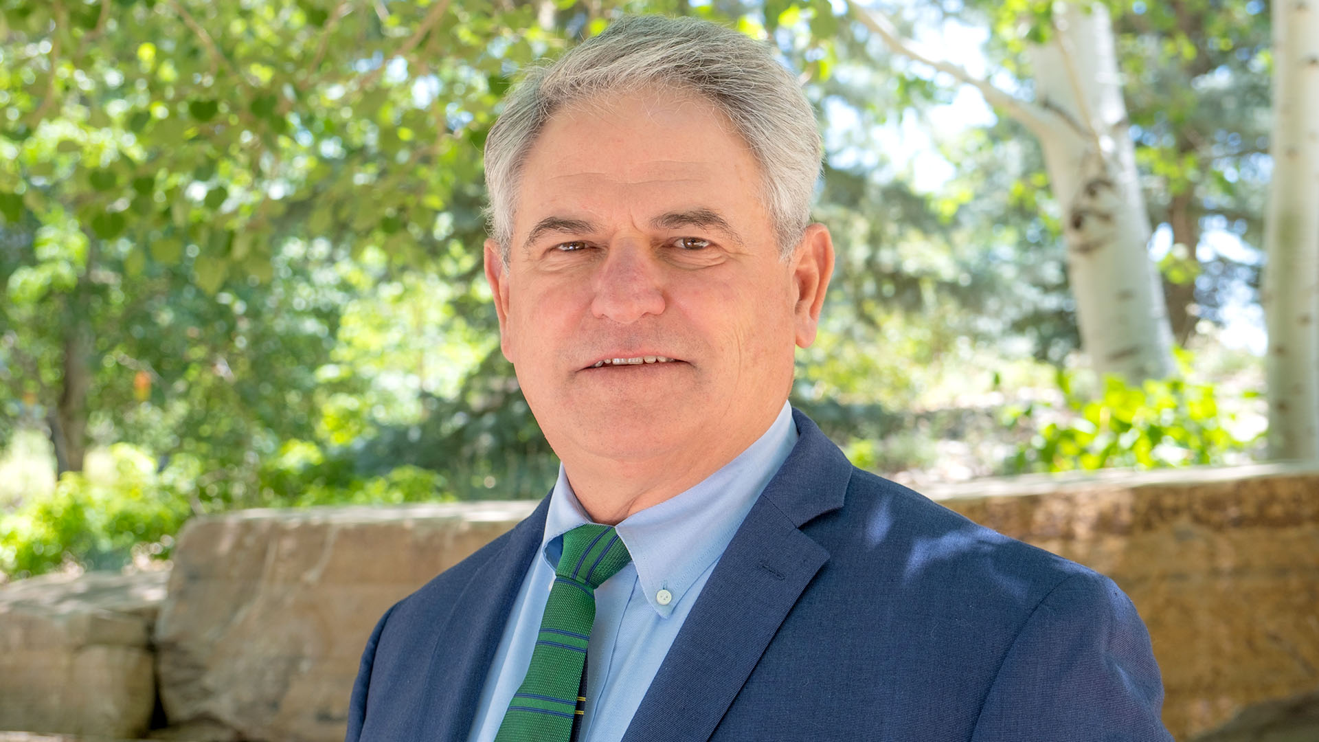 Man in blue suit wear a green tie.