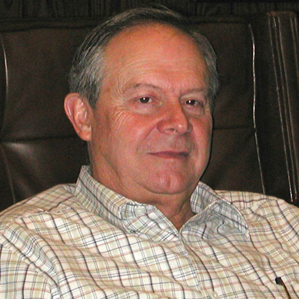 Man wearing a plaid shirt sitting in a recliner.
