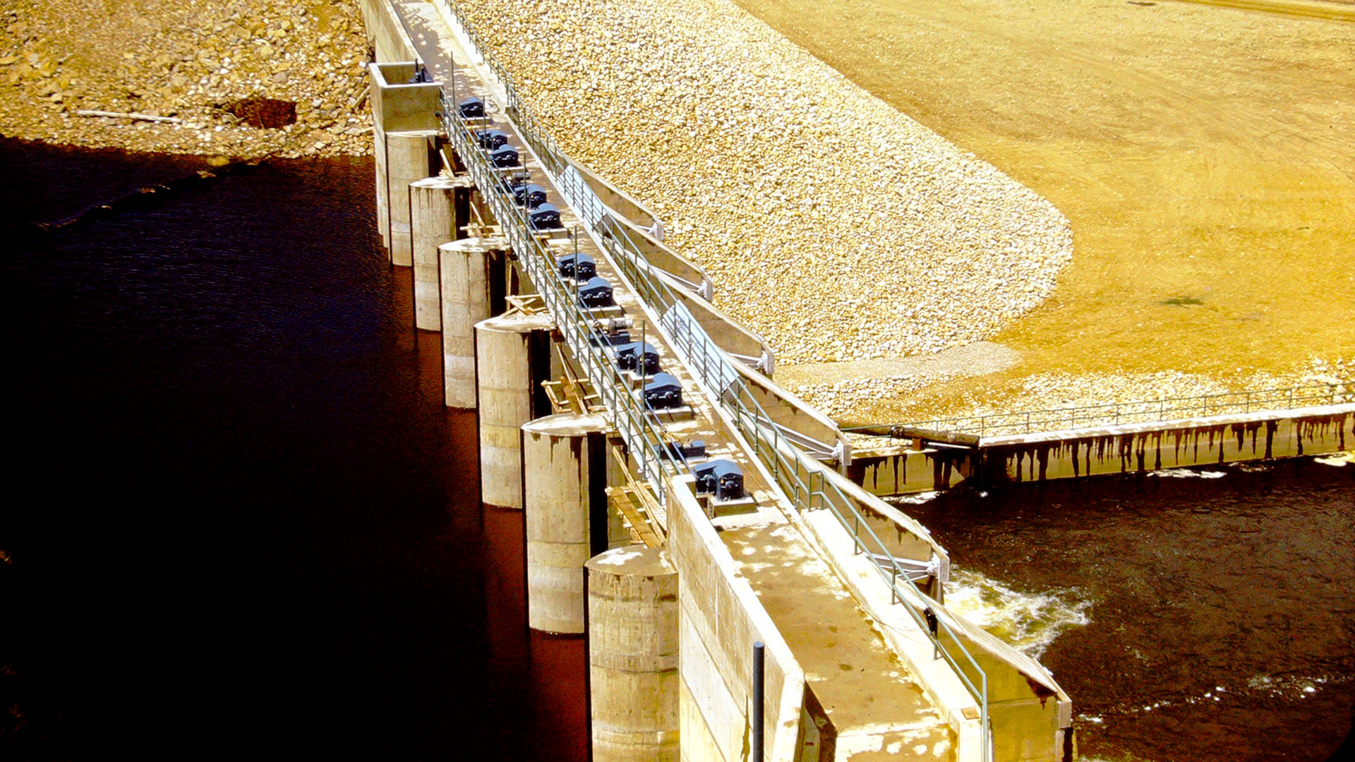 Dam at Lake Estes with lake on the left and downstream river below.