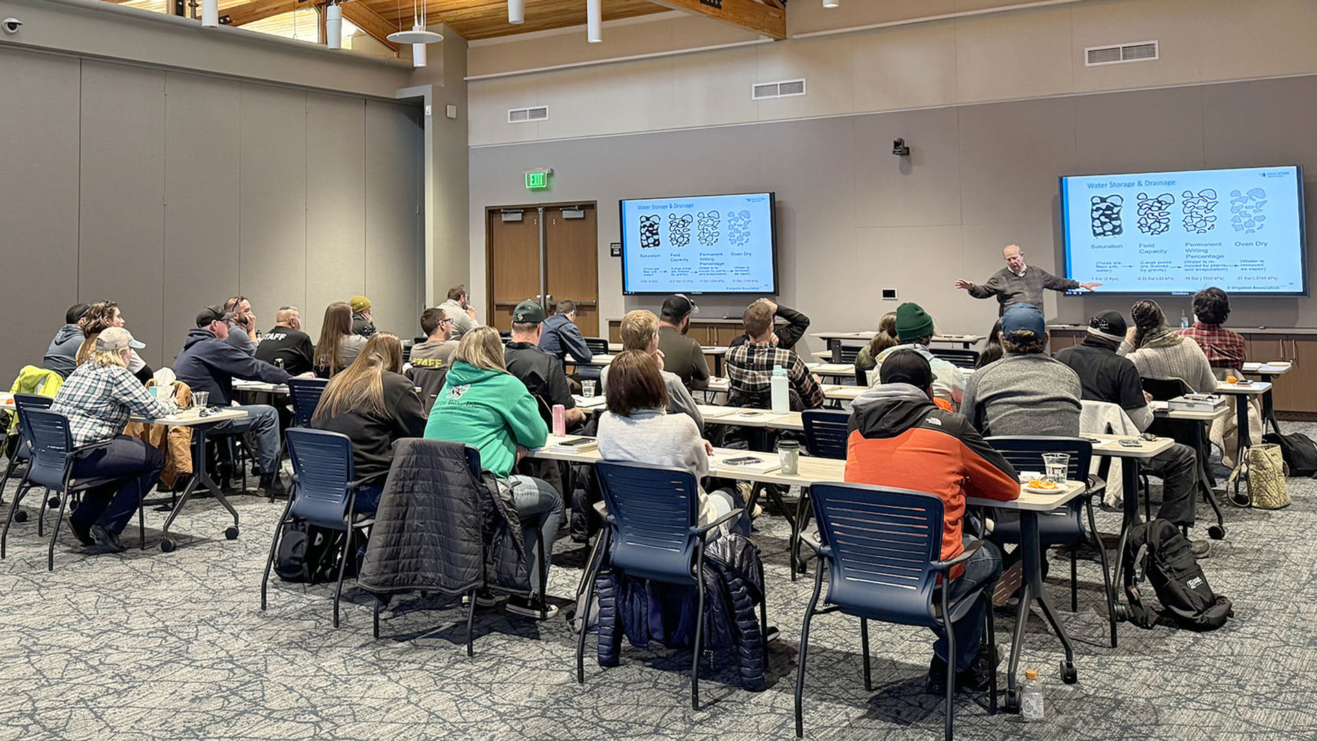 People seated at classroom tables taking a training.