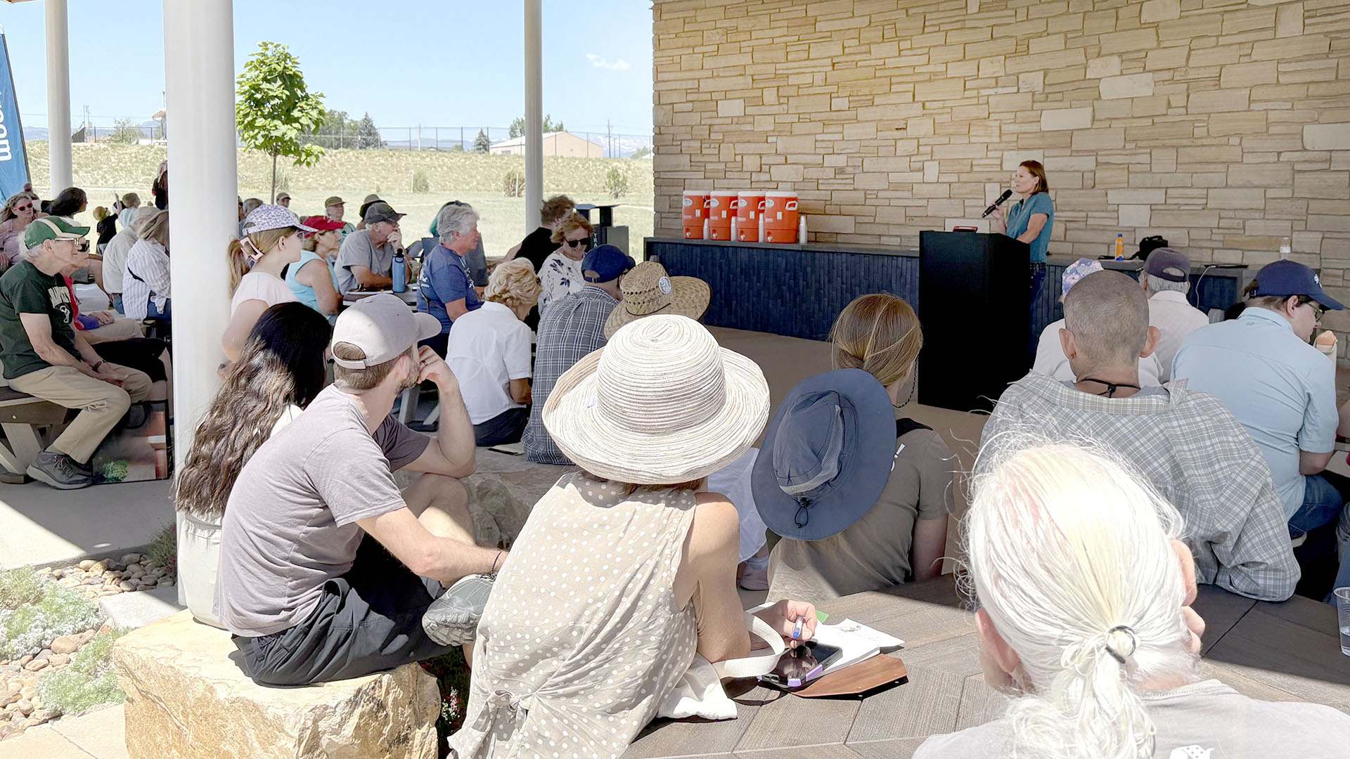 People sitting at tables listening to an educational talk about native grass.