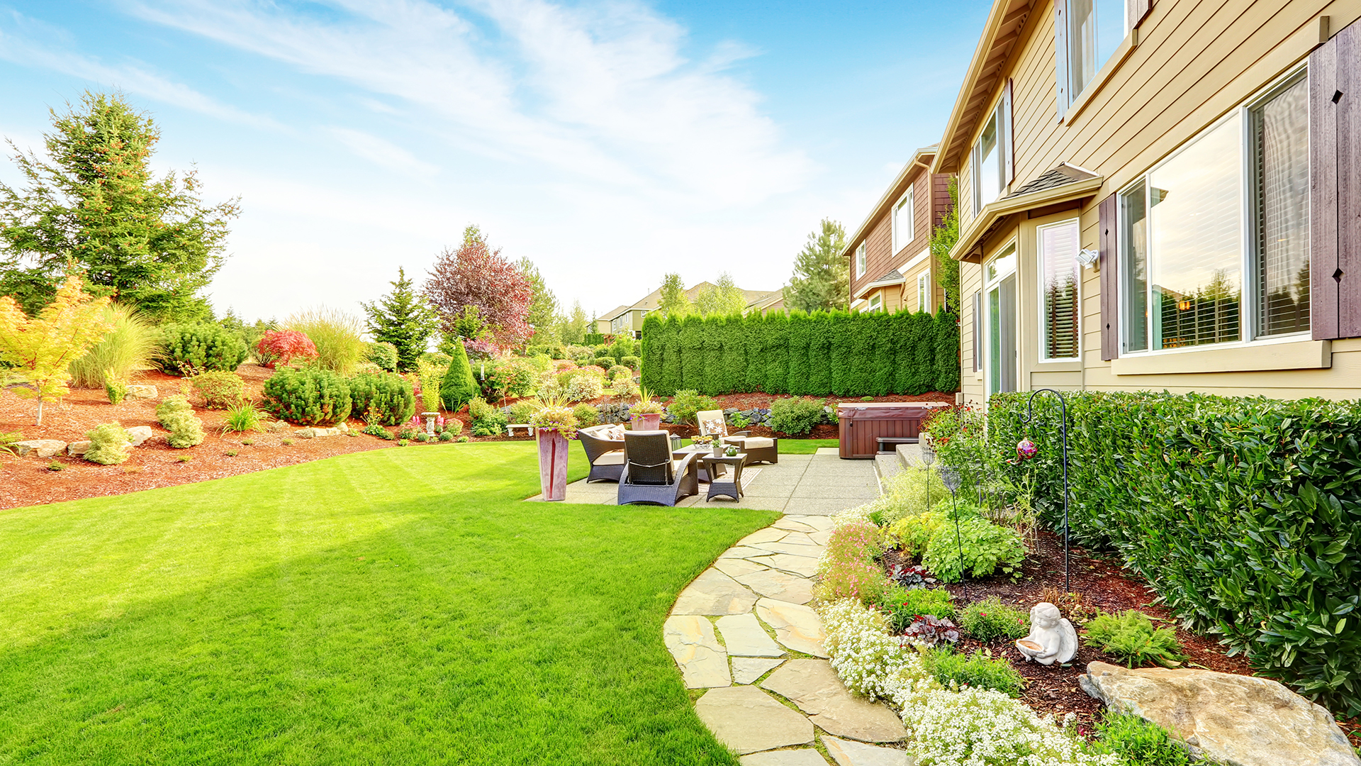 backyard of home with patio, rock path, lawn and planting areas