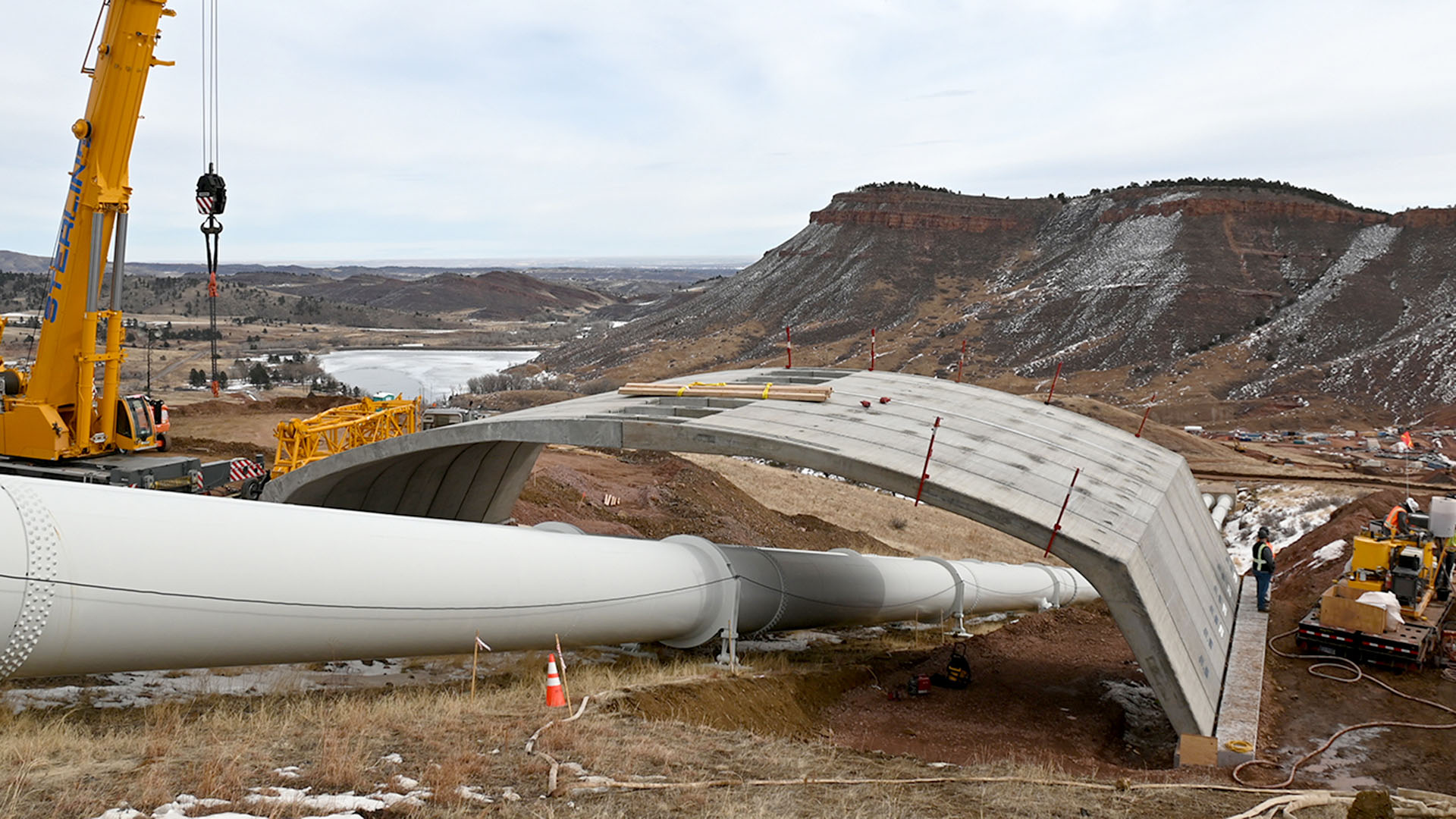 Two sections of a bridge connected over a water pipe. 