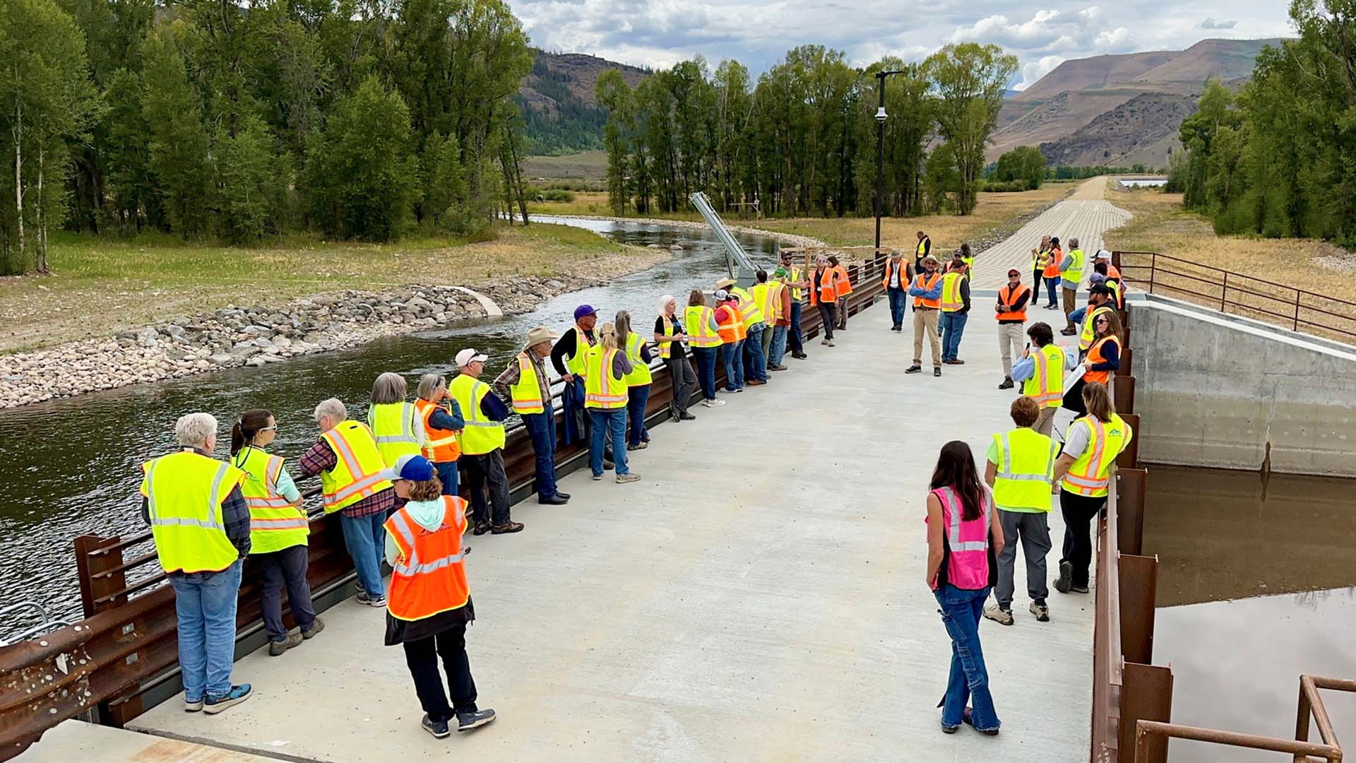 Tour attendees lined up on a bridge listening to a tour.