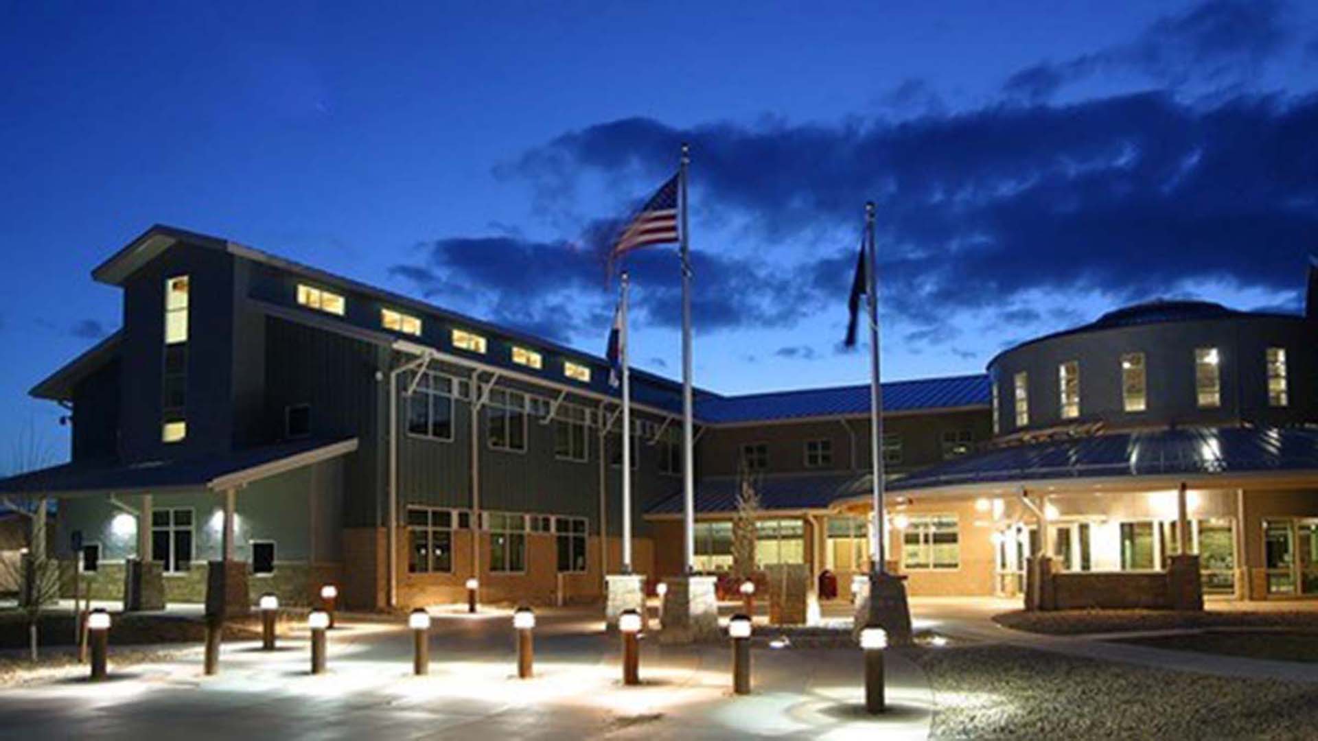 Northern Water campus at night with lights on inside the building.