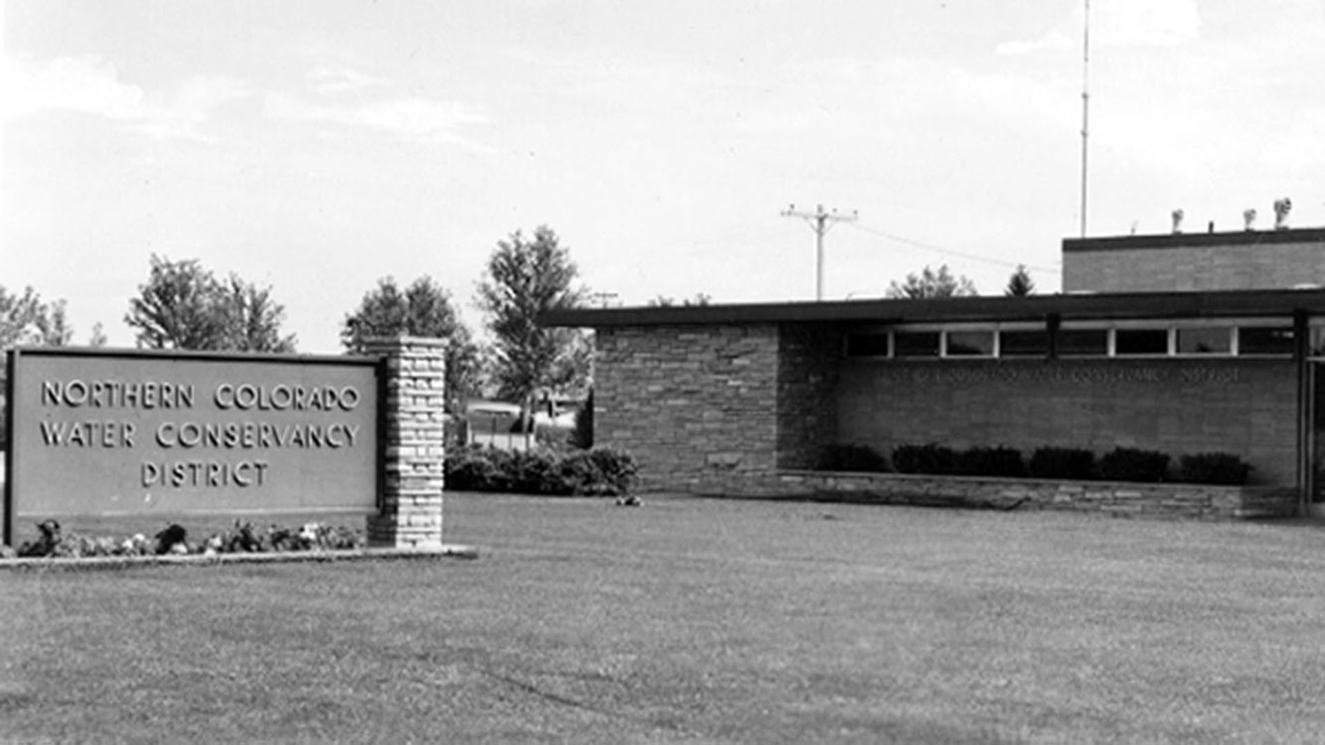 Monument sign in front of a brick building.