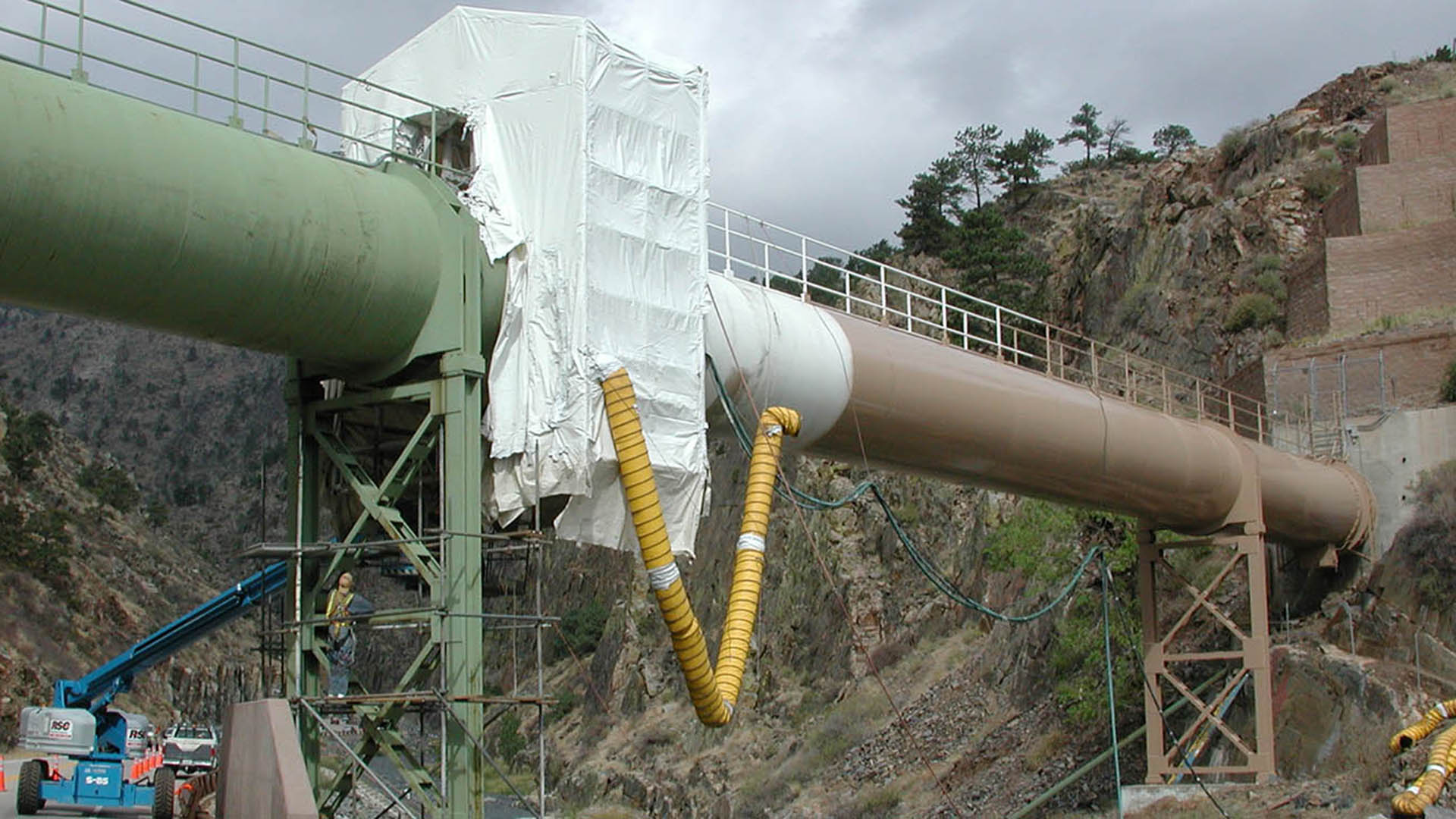Crews painting a large water siphon.
