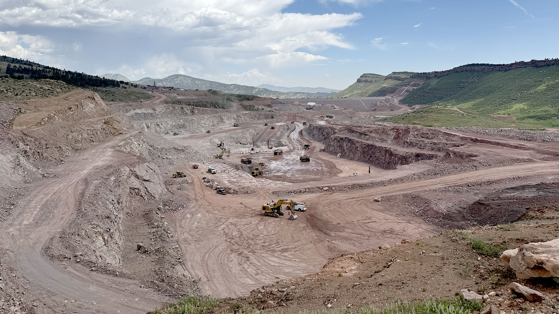 Onsite quarry at Chimney Hollow with trucks and equipment on various levels.