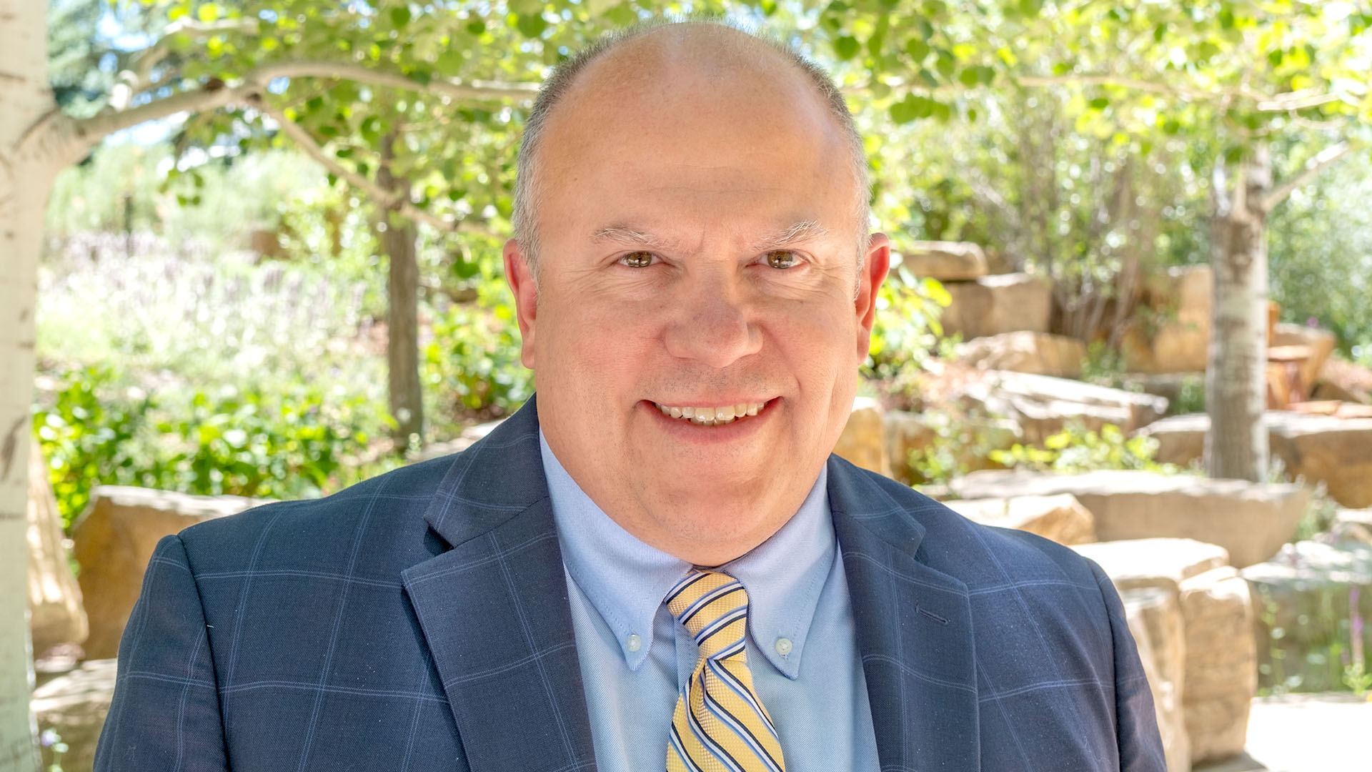 Man in a blue suit with a striped tie.