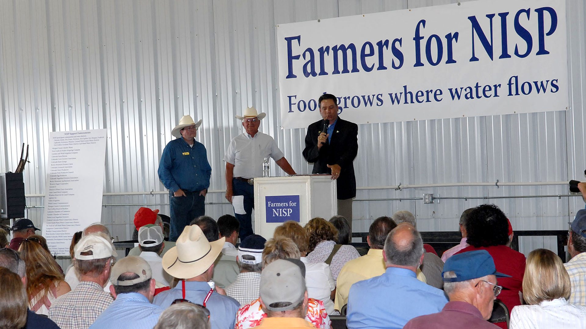 People on a stage talking to a large group of people.