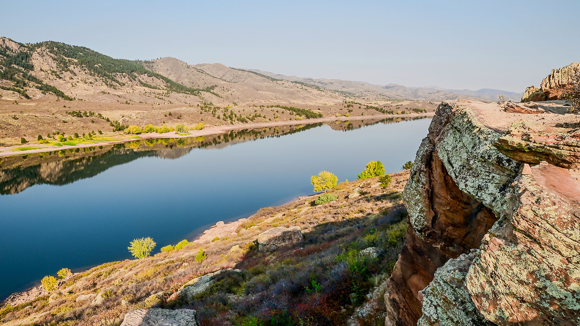 Fall trees and colors in gold and yellow surrounding Horsetooth Reservoir.