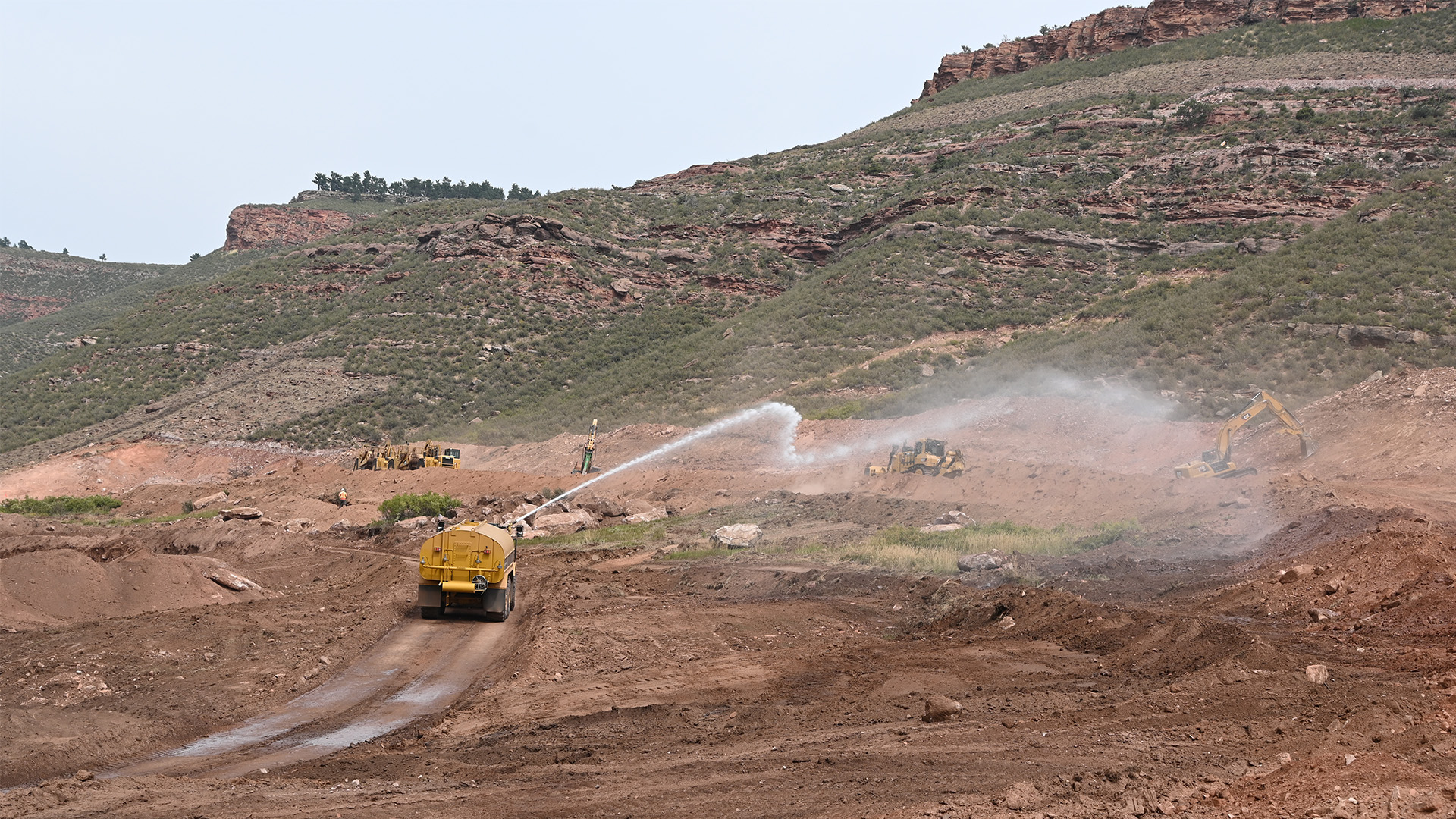 Water truck spraying water on dirt