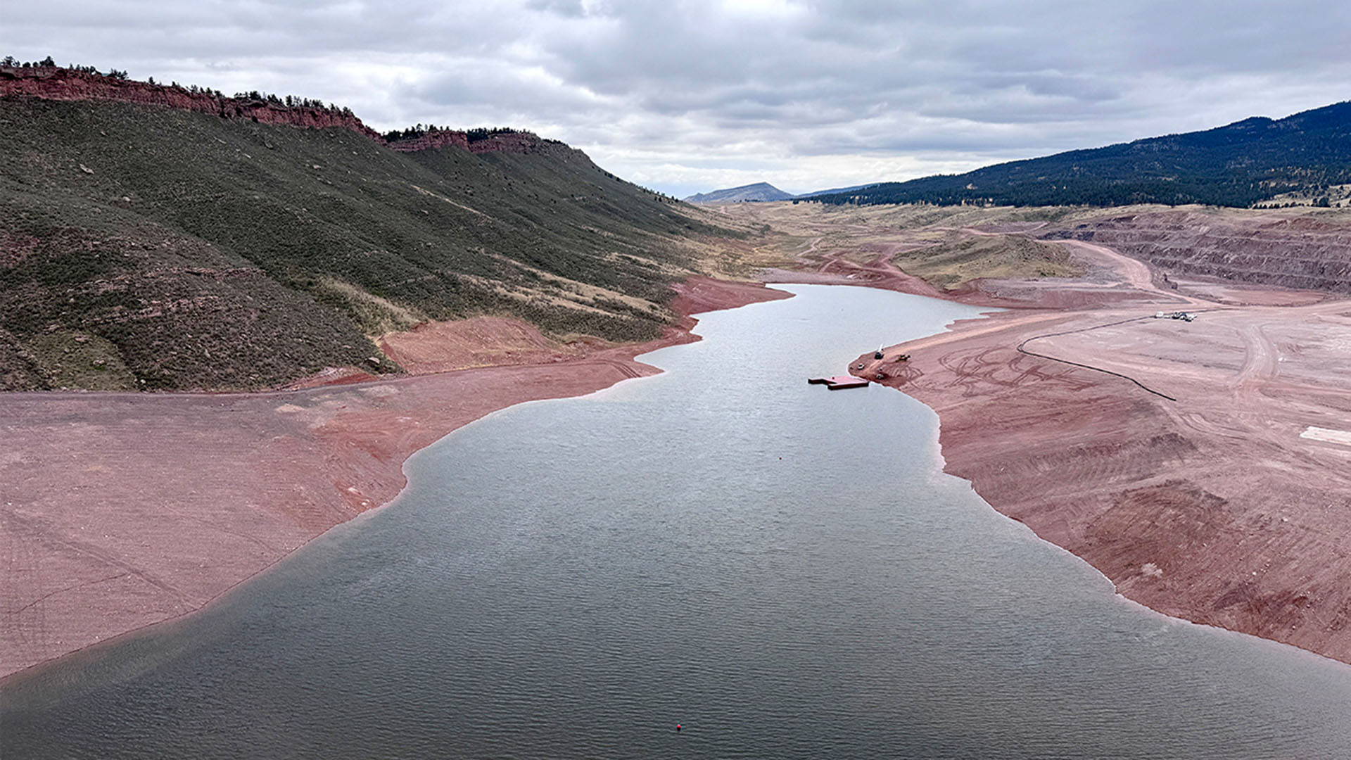A small amount of water in Chimney Hollow Reservoir behind the dam.